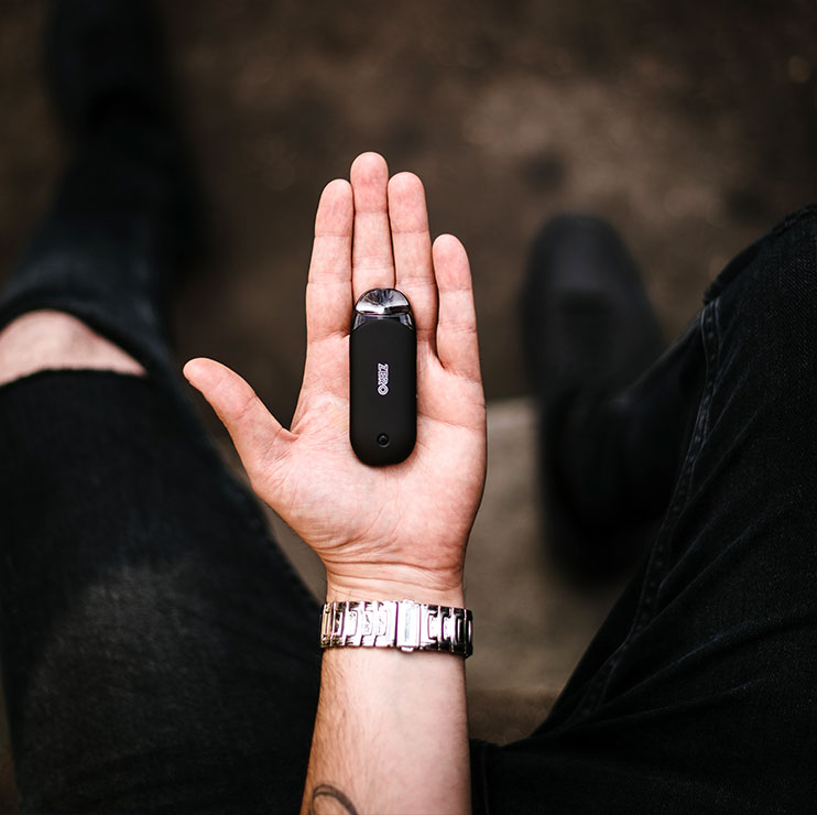 Person Holding Black Vape in Palm of Hand